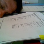 Person sleeping on pile of papers